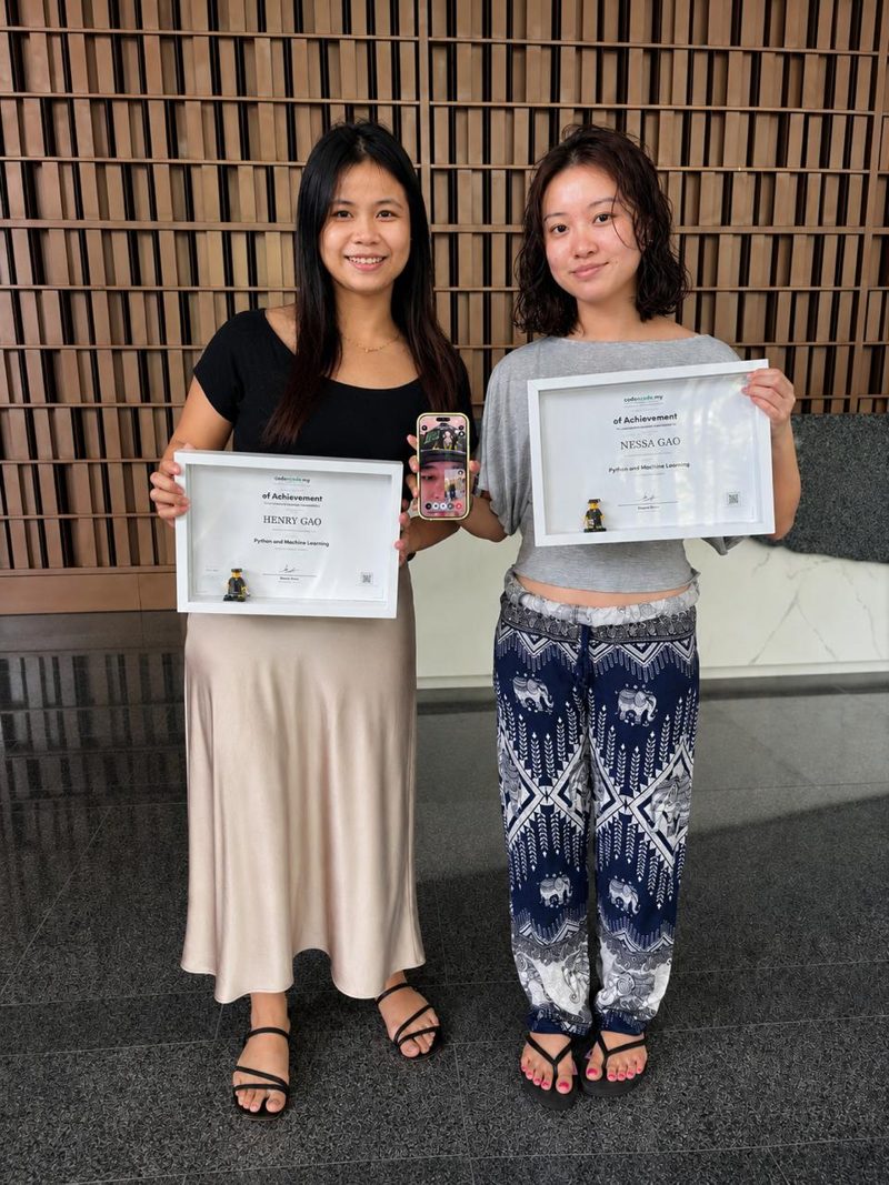 Vanessa and Henry each holding a codencode.my Python and Machine Learning Certificate of Achievement